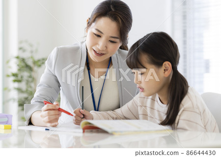 Girl elementary school student receiving individual guidance at a cram school Girl elementary school student receiving individual guidance at a cram school 86644430
