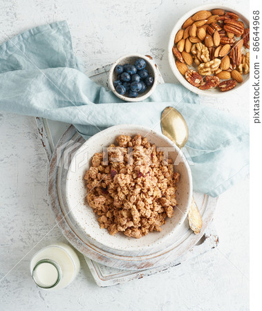 Dry granola in bowl. Breakfast, healthy diet food with milk in bottle, oat flakes Dry granola in bowl. Breakfast, healthy diet food with milk in bottle, oat flakes 86644968