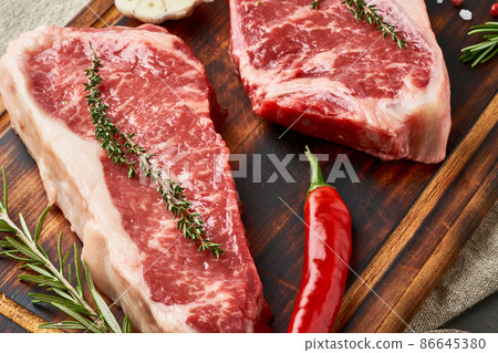 Two big whole piece of raw beef meat, striploin on wooden cutting board, macro, close up Two big whole piece of raw beef meat, striploin on wooden cutting board, macro, close up 86645380