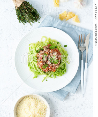 Keto pasta Bolognese with mincemeat and zucchini noodles. Top view, close up, vertical. 86645387