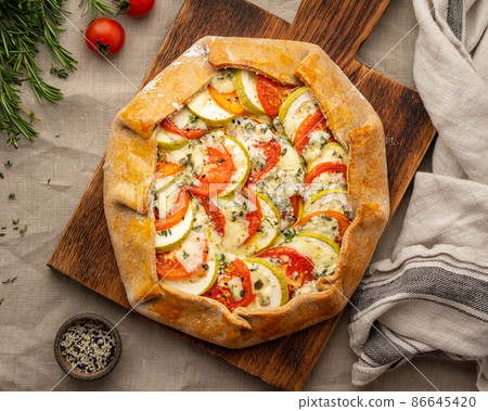 Top view. Homemade savory galette with vegetables, wheat pie with tomatoes, zucchini 86645420