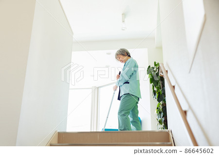 Female staff cleaning the office with a mop Female staff cleaning the office with a mop 86645602
