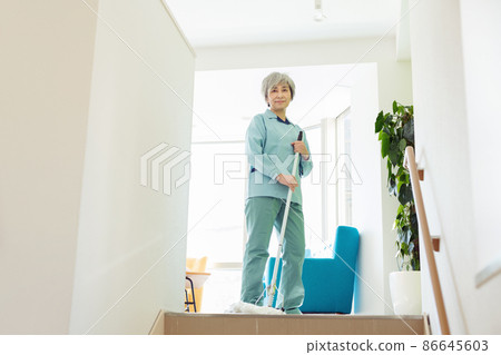 Female staff cleaning the office with a mop Female staff cleaning the office with a mop 86645603