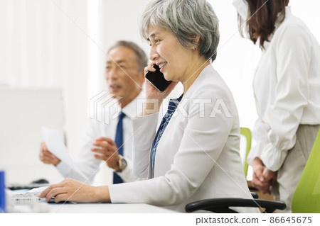 50 多歲的職業女性在智能手機上聊天 86645675