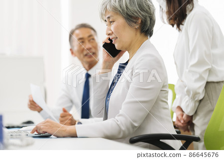 50 多歲的職業女性在智能手機上聊天 50 多歲的職業女性在智能手機上聊天 86645676