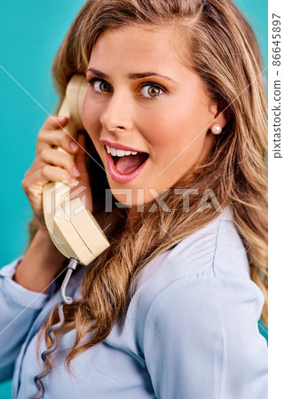 He had me at hello. Studio shot of a young woman holding a telephone while wearing 80s clothing. He had me at hello. Studio shot of a young woman holding a telephone while wearing 80s clothing. 86645897