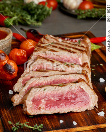 Keto ketogenic diet grilled fried beef steak, striploin on cutting board, side view, vertical Keto ketogenic diet grilled fried beef steak, striploin on cutting board, side view, vertical 86646015