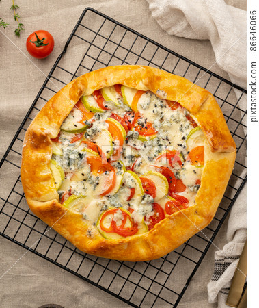 Homemade savory galette with vegetables, wheat pie with tomatoes, zucchini, vertical 86646066
