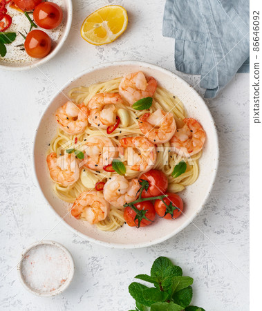 Pasta bavette with fried shrimps, bechamel sauce, mint leaf, garlic, on white plate, top view 86646092