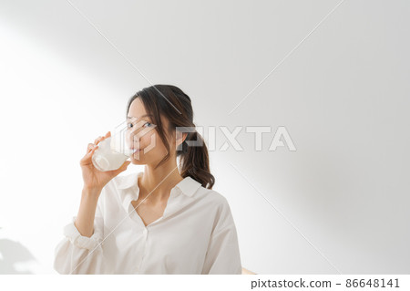 Female drinking milk white background 86648141