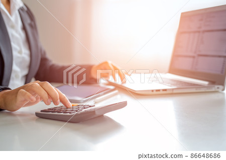 Business woman using calculator to calculate the sum of numbers. Business woman using calculator to calculate the sum of numbers. 86648686