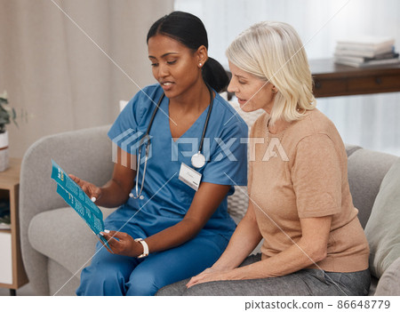 Get informed, make a good decision. Shot of a doctor reading a pamphlet about Covid-19 on the sofa at home. 86648779