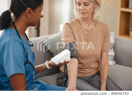 Blood pressure, detect and protect. Shot of a doctor examining a senior woman with a blood pressure gauge at home. 86648783
