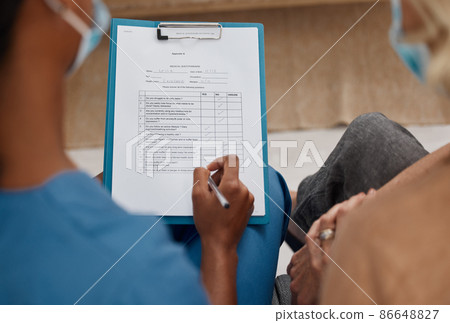 A thorough consultation starts with a concise medical history. Shot of a doctor filling out a questionnaire during a consultation with a senior woman at home. 86648827