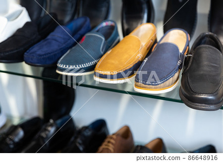 Suede and leather mens loafers for sale on glass shelf Suede and leather mens loafers for sale on glass shelf 86648916