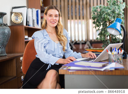 Successful businesswoman working with paperwork and laptop Successful businesswoman working with paperwork and laptop 86648918