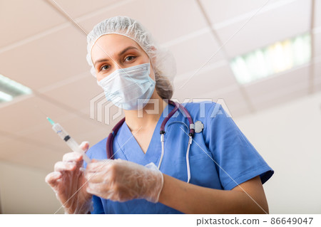 Female doctor in mask preparing syringe for vaccination 86649047