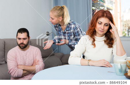 Husband and wife quarrelling indoors, senior mother taking it hard 86649104