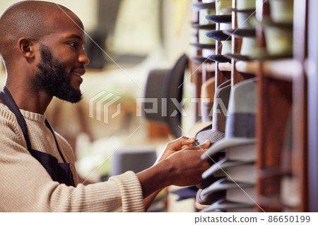Surround yourself with other supportive businessmen. Shot of a young man working at his job in a shop. 86650199
