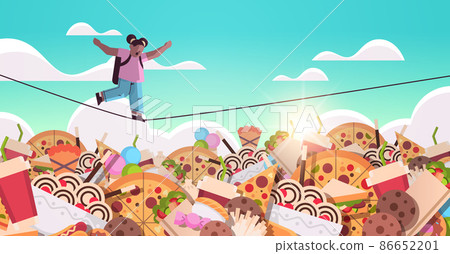 schoolgirl balancing on rope above junk food assortment of fast food unhealthy nutrition junkfood addiction schoolgirl balancing on rope above junk food assortment of fast food unhealthy nutrition junkfood addiction 86652201