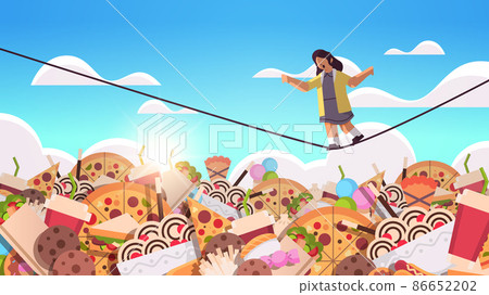 schoolgirl balancing on rope above junk food assortment of fast food unhealthy nutrition junkfood addiction concept schoolgirl balancing on rope above junk food assortment of fast food unhealthy nutrition junkfood addiction concept 86652202