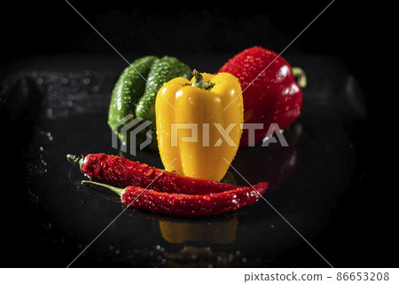 Chili and Bell Peppers over Dark Background. Horizontal View. Natural Organic and Vegan Food Concept Chili and Bell Peppers over Dark Background. Horizontal View. Natural Organic and Vegan Food Concept 86653208