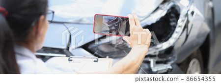Woman insurance agent taking pictures of broken car on mobile phone closeup Woman insurance agent taking pictures of broken car on mobile phone closeup 86654355