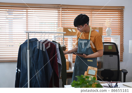Happy young asian man working at warehouse for online seller. Happy young asian man working at warehouse for online seller. 86655181