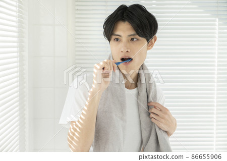 Young man brushing his teeth 86655906