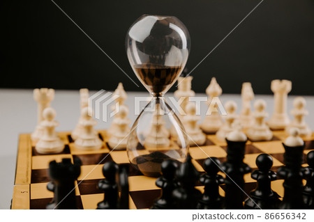 Hourglass stands on a chessboard. Leadership and business strategy concept Hourglass stands on a chessboard. Leadership and business strategy concept 86656342
