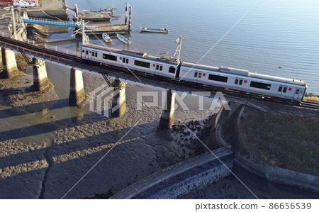 817 series ordinary train running on the bridge of the tidal flat 86656539
