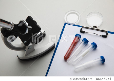 Laboratory test concept. Microscope and test tube on white background top view 86656731
