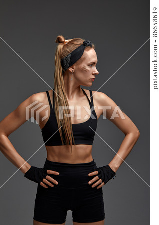 Portrait of female anger, animal instinct, demonstrating their incredible flexibility with the movement of animal flow in the studio on a gray background. 86658619
