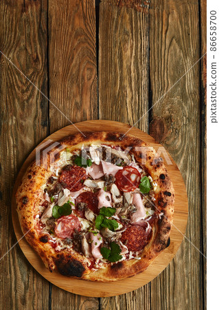 Meat Italian pizza with roast beef, steak slices, melted cheese, with olive slices and cheddar cheese. Close up, macro. Pizza time concept. 86658700