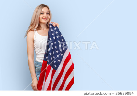Portrait of a young woman holding USA flag isolated on color background 86659094