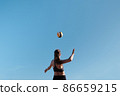 Athlete jumps and kicks a volleyball. Summer sport Beach volleyball. 86659215