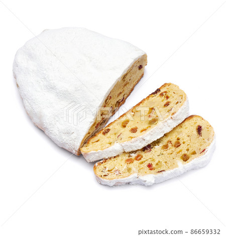 Sliced Traditional Christmas stollen cake with marzipan and dried fruit isolated on white background 86659332