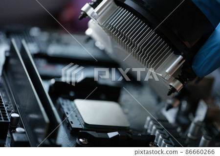 Someone install cooler fan with copper tubes on computer processor, sterile glove for work Someone install cooler fan with copper tubes on computer processor, sterile glove for work 86660266