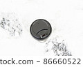 A large disposable paper cup with a lid for hot drinks on a snowy background. 86660522