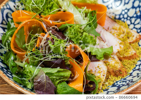 Pumpkin salad with chicken and arugula on a vintage plate over dark blue slate,stone or concrete background. 86660694