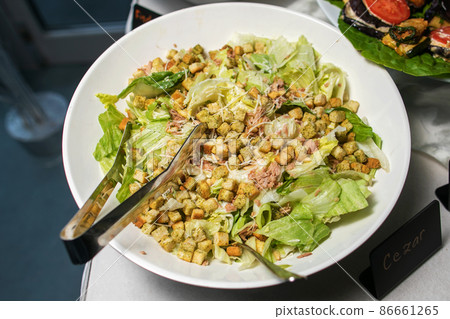 Delicious caesar salad with parmesan cheese, homemade croutons and dressing. Delicious caesar salad with parmesan cheese, homemade croutons and dressing. 86661265