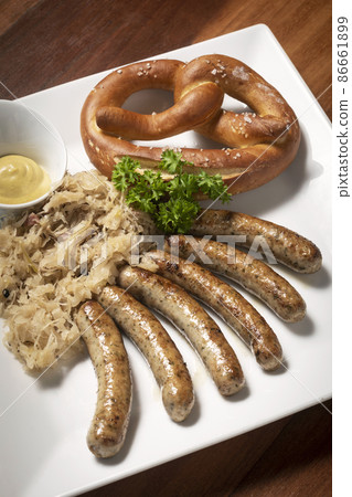 traditional german bavarian meal of sausages with sauerkraut and pretzel 86661899