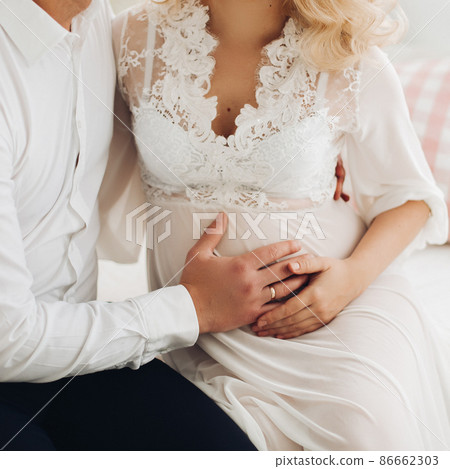 Beautiful couple embracing stomach and touching Beautiful couple embracing stomach and touching 86662303