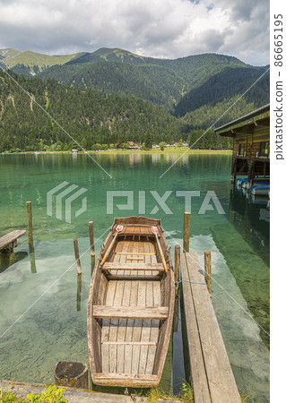 Picture of wooden paddle boat at small pier on east shore of Weissensee lake in Austria 86665195