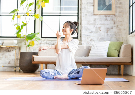 Young woman doing online yoga at home 86665807