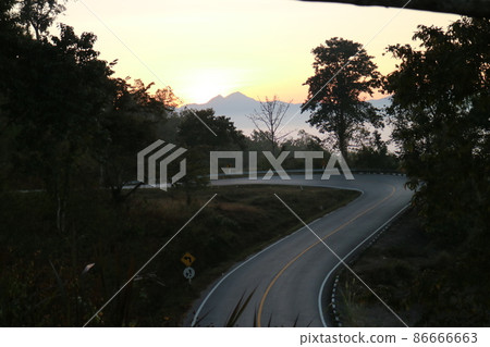 There is a winding road in the woods in the mountains 86666663