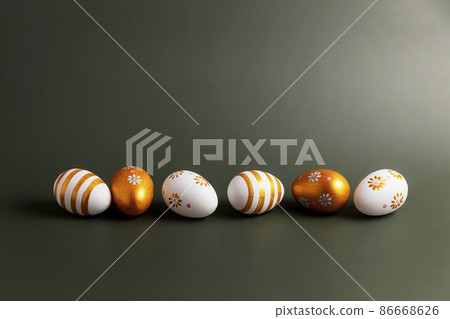 Easter holiday conceptual background on green table. Top view from above to different golden painted Easter eggs flat lay. Card with copy space to place text. Minimal concept. High quality photo Easter holiday conceptual background on green table. Top view from above to different golden painted Easter eggs flat lay. Card with copy space to place text. Minimal concept. High quality photo 86668626