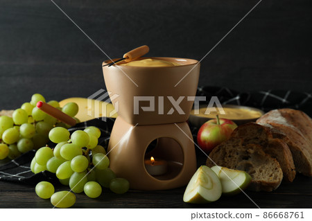 Concept of delicious food with fondue on wooden table 86668761