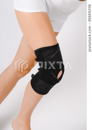 Knee Support Brace on leg isolated on white background. Elastic orthopedic orthosis. Anatomic braces for knee fixation, injuries and pain. Protective knee joint bandage sleeve. Trauma, rehabilitation. Knee Support Brace on leg isolated on white background. Elastic orthopedic orthosis. Anatomic braces for knee fixation, injuries and pain. Protective knee joint bandage sleeve. Trauma, rehabilitation. 86669206