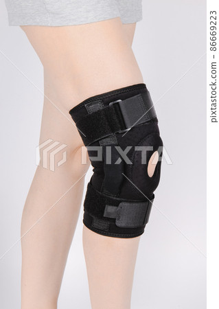 Knee Support Brace on leg isolated on white background. Elastic orthopedic orthosis. Anatomic braces for knee fixation, injuries and pain. Protective knee joint bandage sleeve. Trauma, rehabilitation. 86669223